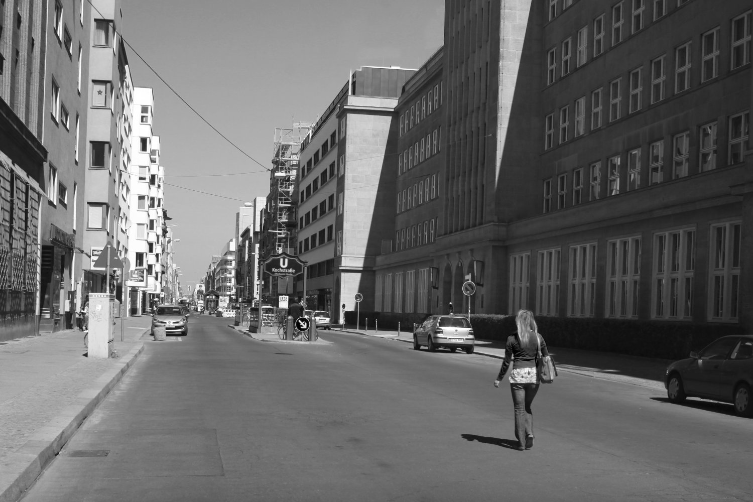 Schwarzweiß-Straßenfotografie der Berliner Kochstraße mit Fußgängerin und modernen Gebäuden