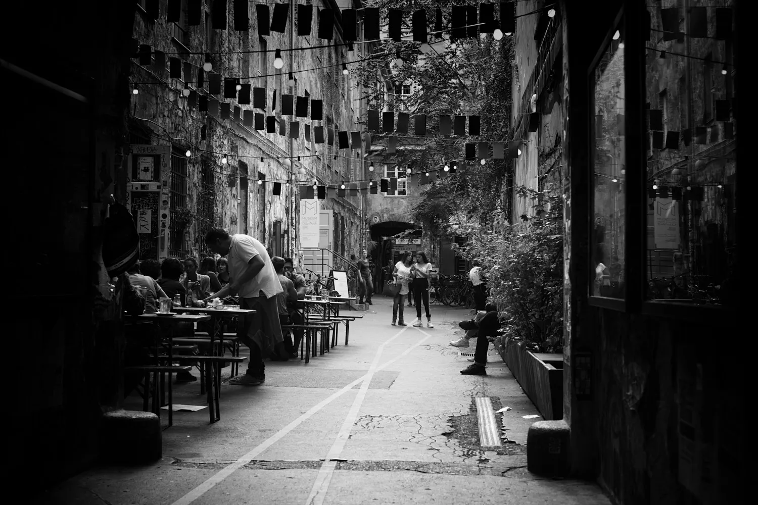 Schwarz-Weiß Foto eines belebten Innenhofs in den Hackesche Höfen Berlin mit historischen Gebäuden