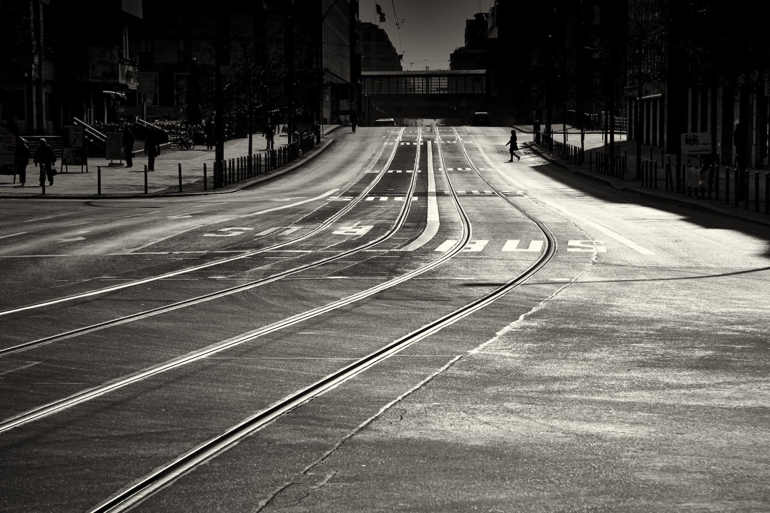 Schwarz-weiß Fotografie der Friedrichstrasse in Berlin mit Straßenbahngleisen und historischen Gebäuden