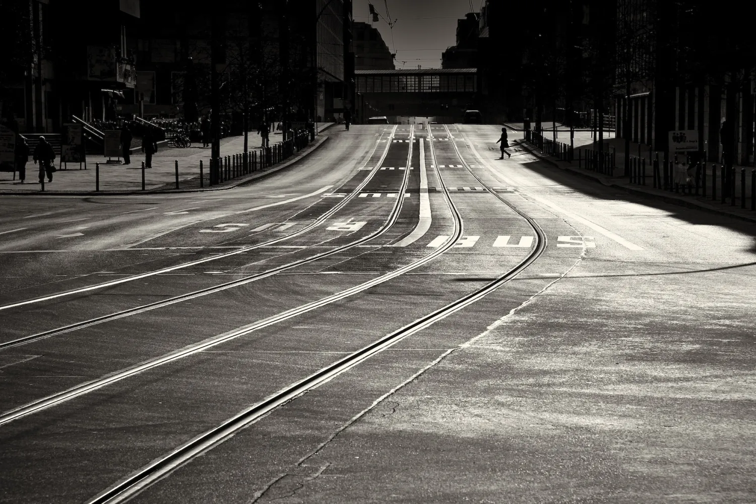 Schwarz-weiß Fotografie der Friedrichstrasse in Berlin mit Straßenbahngleisen und historischen Gebäuden