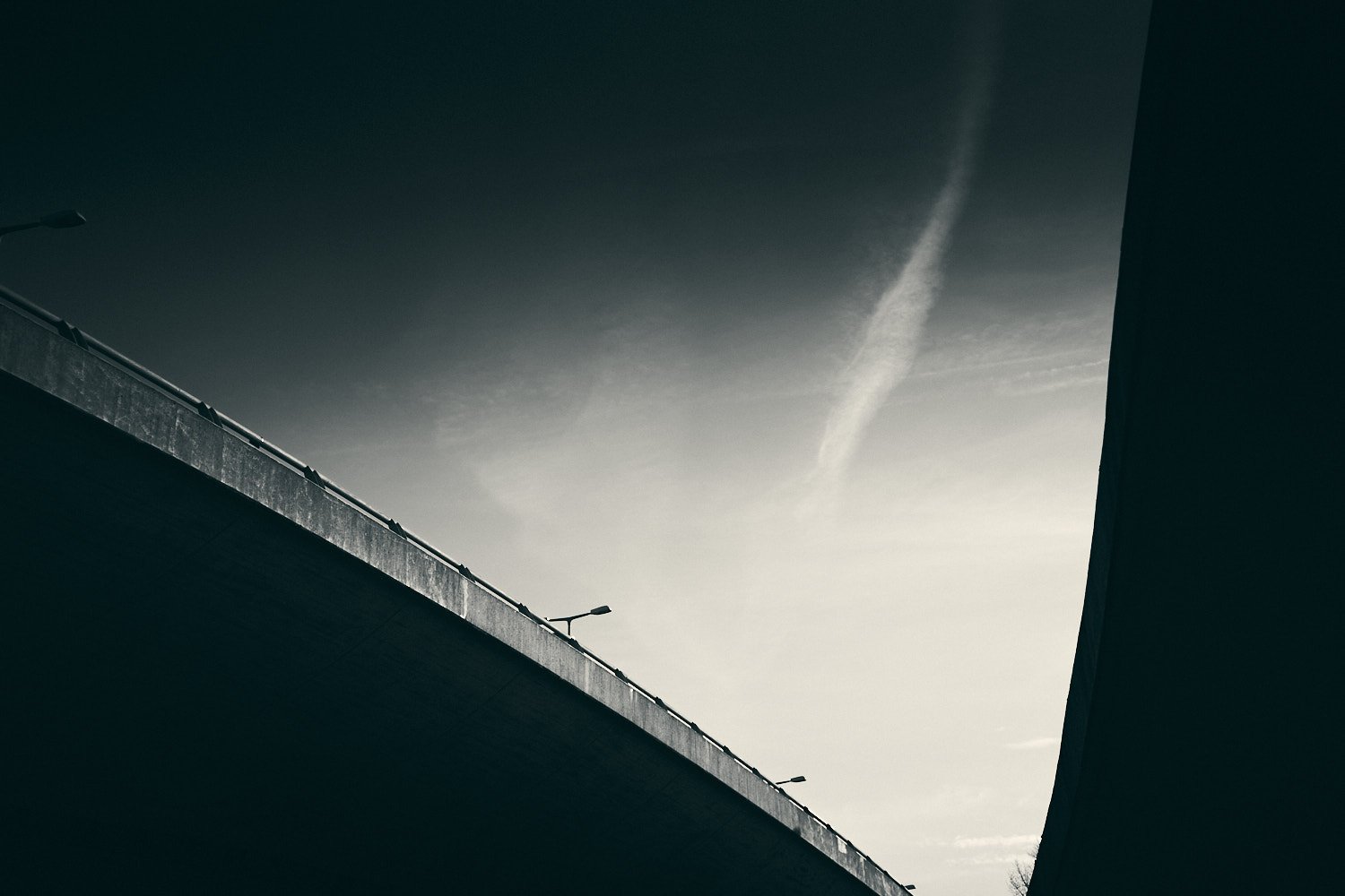 Concrete highway bridge in Berlin Wilmersdorf against dramatic sky with contrails