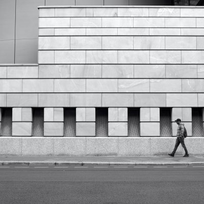 Person läuft vor moderner Architektur der britischen Botschaft in Berlin Mitte