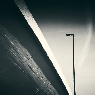 Street lamp against concrete highway bridge 