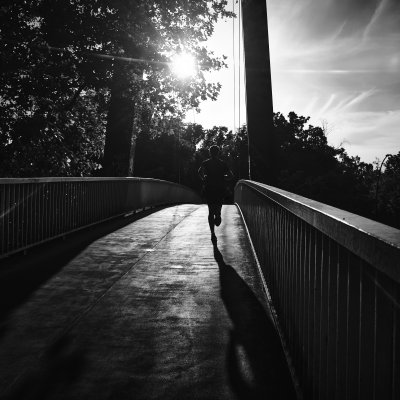Runner runs over bridge into sun